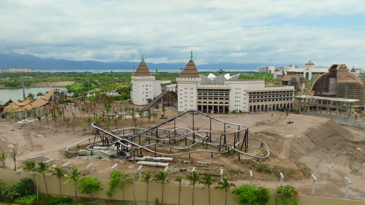 Aerial view of roller coaster structure and castle style building at VidantaWorld under cloudy sky, Mexico