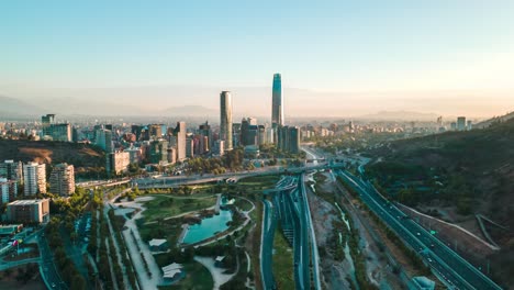 Lufthyperlapse-Des-Sonnenuntergangs-über-Dem-Zweihundertjährigen-Park-Von-Vitacura-In-Santiago-De-Chile-Mit-Dem-Finanzviertel-Im-Hintergrund---Drohnenaufnahme