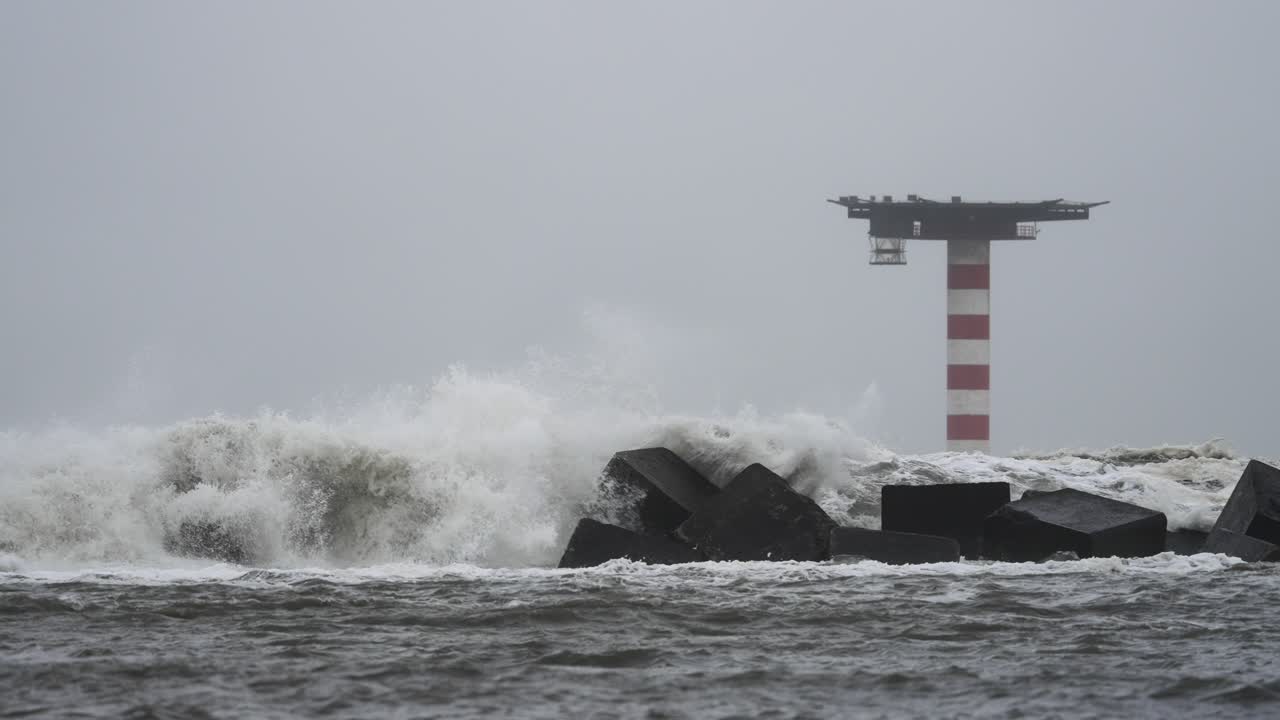 조수, 해류, 파도, 폭풍 해일로부터 보호하기 위해 건설된 방파제 구조물에 부딪히면서 극심한 악천후로 인한 거대한 파도의 정지 영상