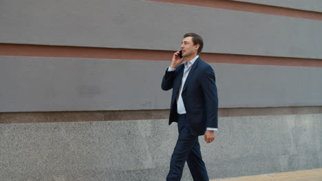 side view of man talking smartphone outdoors