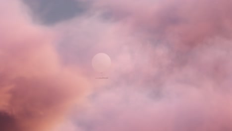 spy balloon revealed from behind clouds at sunset