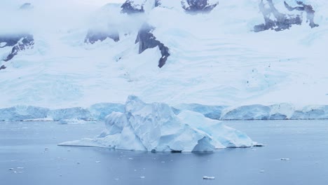 Paisaje-De-Iceberg-Invernal-Antártico-En-La-Costa-En-Un-Frío-Paisaje-Azul-De-La-Península-Antártica-Con-Nieve-Nevada,-Hielo-Y-Glaciar-En-Una-Espectacular-Y-Hermosa-Escena-Costera-Con-Agua-De-Mar-Oceánica