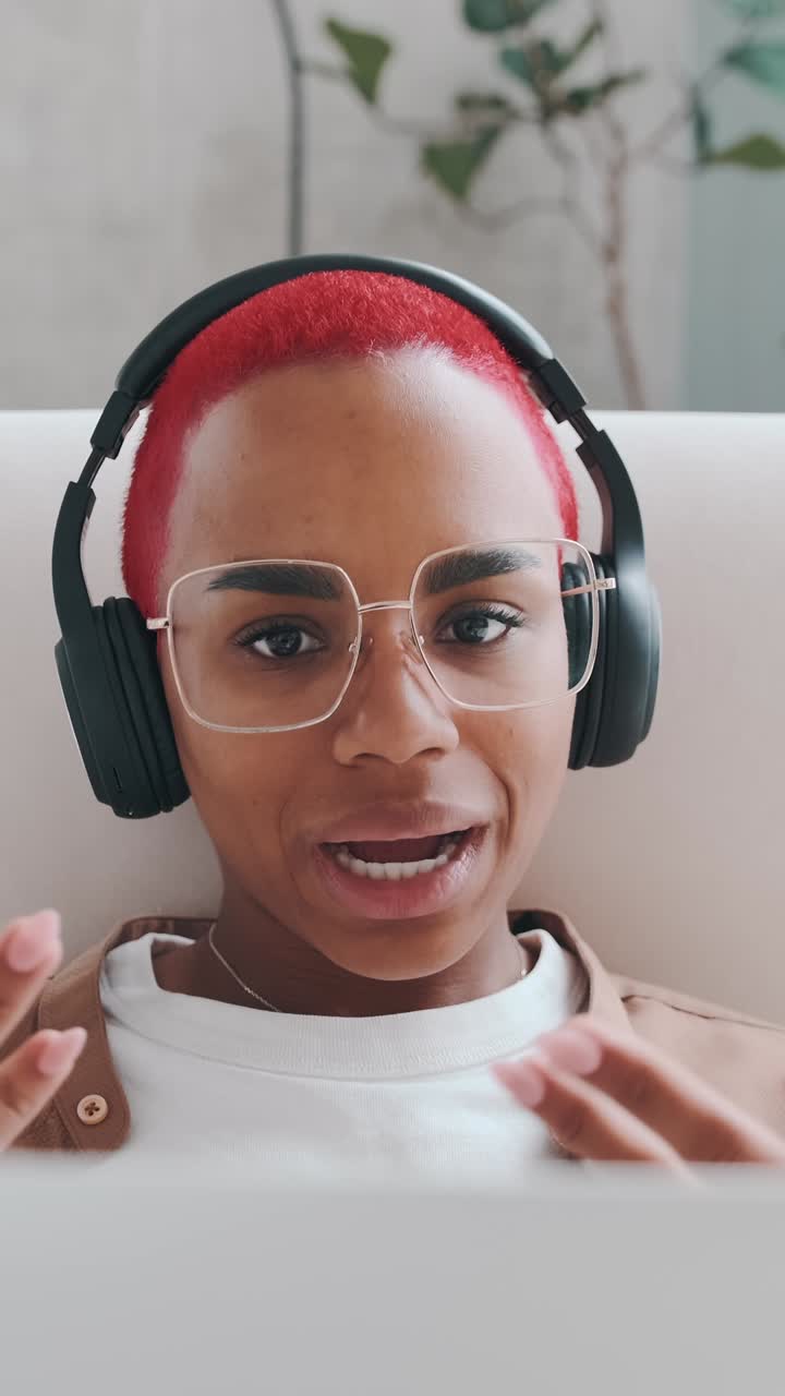 Smiling person with red hair listens to music in modern workspace setup