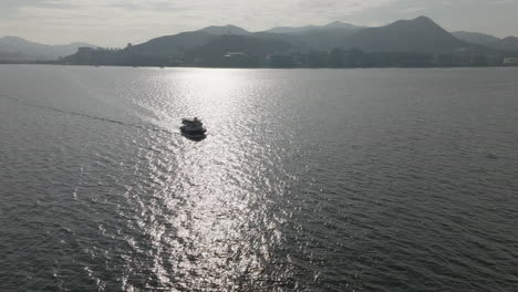 Drone-shot-of-tourism-Boat-on-the-watery-in-the-city-in-Hong-Kong,-China