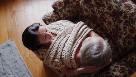 a mother and daughter share a loving moment in an armchair