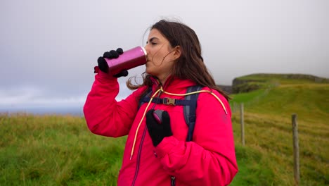 Frau-Schließt-Eine-Thermoskanne,-Nachdem-Sie-Beim-Wandern-In-Mykines-Etwas-Wasser-Getrunken-Hat