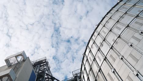 grain elevator on sky background. large industrial granary. modern silo for drying and processing grains. view from below