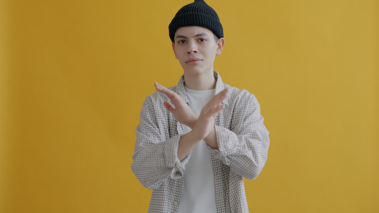 Teenager rejecting gesture against yellow background