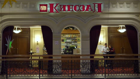 person walking passed bar in gum department store in moscow at night