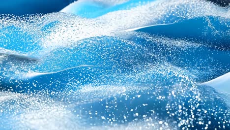a blue and white fabric with a wavy pattern. the fabric is covered in silver and white glitter