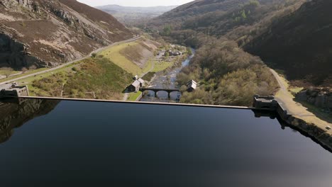 An-aerial-view-of-Caban-Coch-dam-and-reservoir-on-a-sunny-spring-day-in-the-Elan-valley,-Powys,-Wales