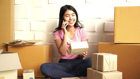 Asian-Women-business-owner-working-at-home-with-packing-box-on-workplace