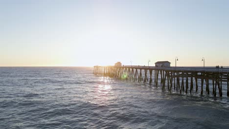 dramatic aerial drone shot of san clemente pier - california, during sunset and calm waters