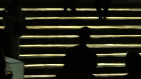 Silhouettes-of-people-going-up-and-down-against-lighting-gold-stairway-Bangkok-Thailand