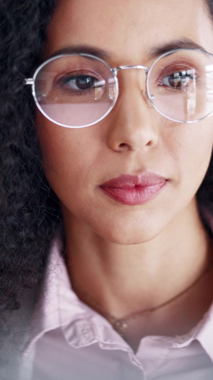 Close-up of a Young Woman Wearing Glasses Looking Thoughtful