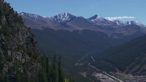 Snow-on-peaks-Copper-Mountain-Leadville-Colorado-aerial-cinematic-drone-early-fall-yellow-aspen-trees-colors-afternoon-Keystone-Breckenridge-Silverthorne-Vail-Ten-Mile-Range-blue-sky-backward-motion