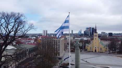 tallinn city flag waiving in the wind, cityscape background