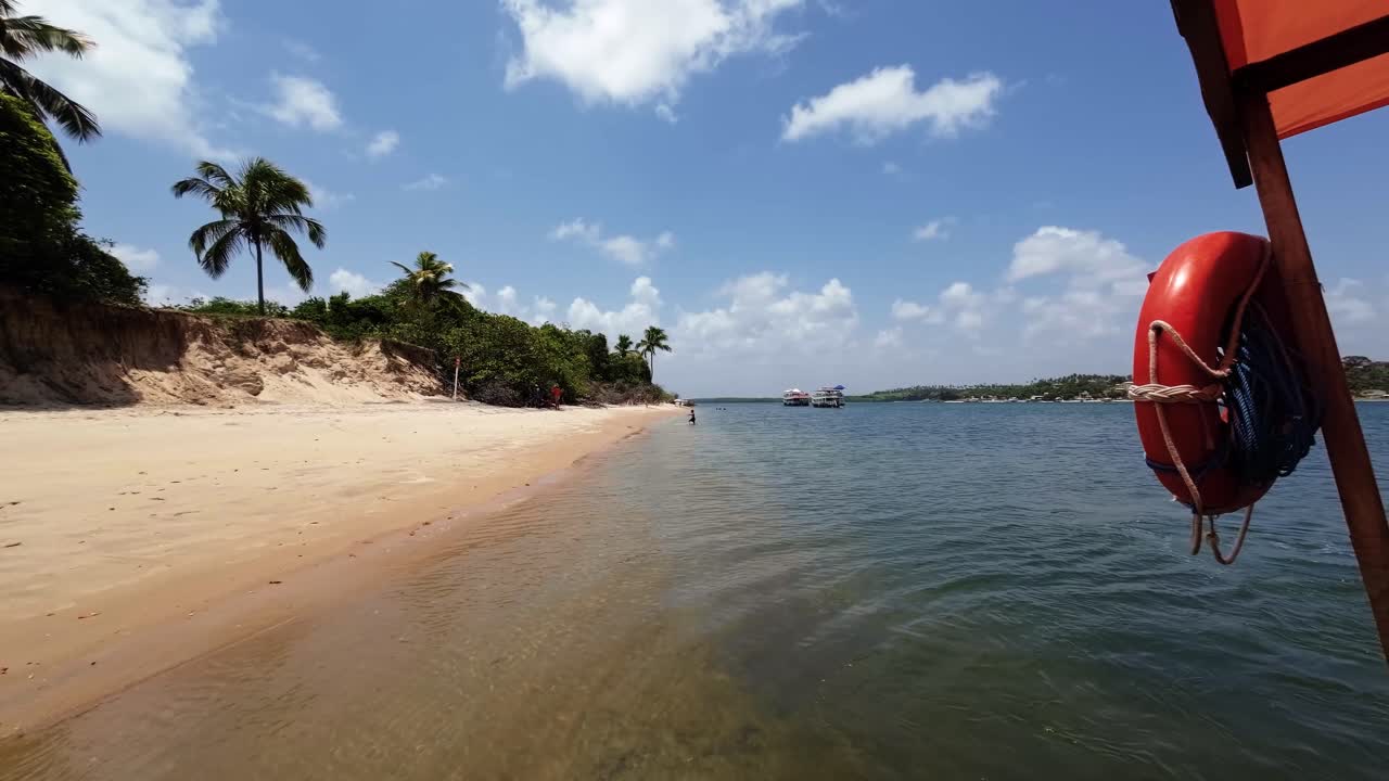 Slow motion action camera shot from on board of a small tourist boat docked on the tropical Restinga beach near Barra do Cunhaú in Rio Grande do Norte, Brazil on a warm sunny summer day
