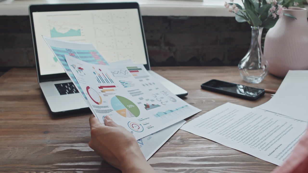 Businesswoman Examining Charts and Diagrams on Business Documents