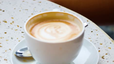 coffee cup with latte art on table