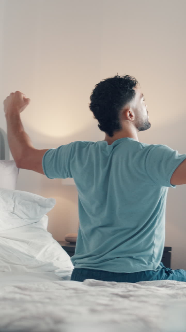 Uomo che si sveglia e si allunga nel letto al mattino