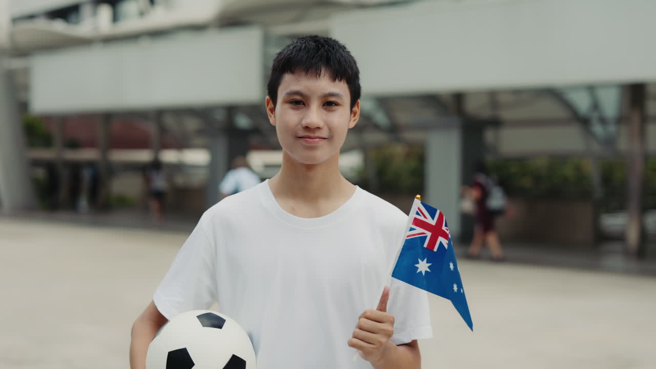 Young Man Holding Australian Flag and Soccer Ball