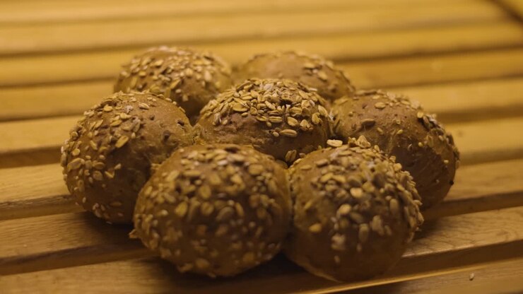 Bun balls covered with sesame seeds baked in the oven are displayed on the wooden shelf