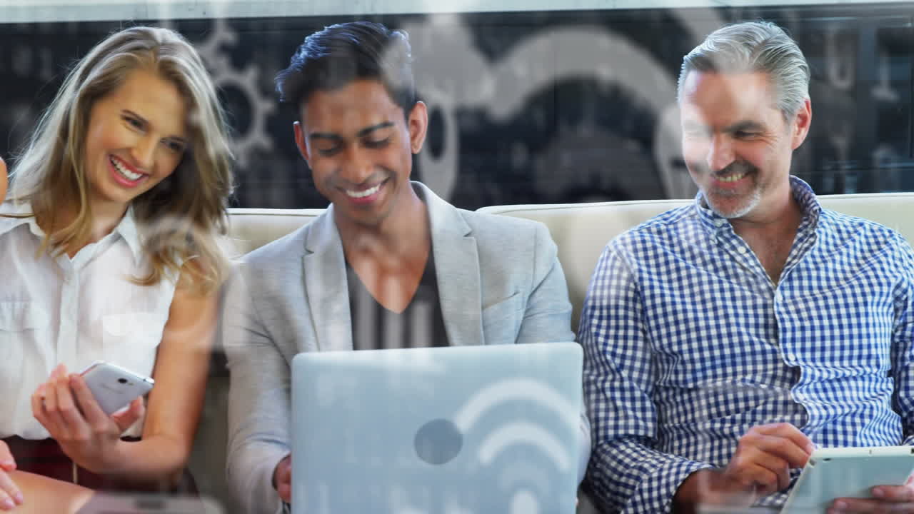 Digital icons against office colleagues using electronic devices