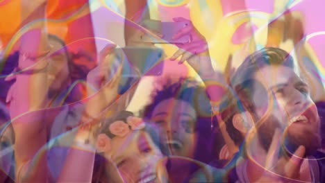 formas abstractas coloridas moviéndose contra un grupo de personas bailando en un concierto