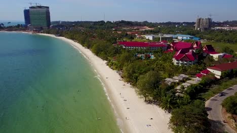 Flying-parallel-to-the-beach,-clear-sky,-clear-sea,-white-sand