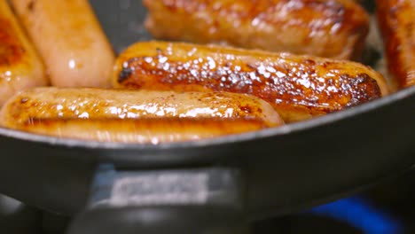 meatless plant based sausages being tossed in a frying pan with crispy skin. healthy meat alternative food source made with real ingredients