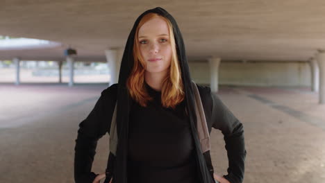 portrait-of-young-friendly-woman-student-smiling-wearing-hoodie-on-campus