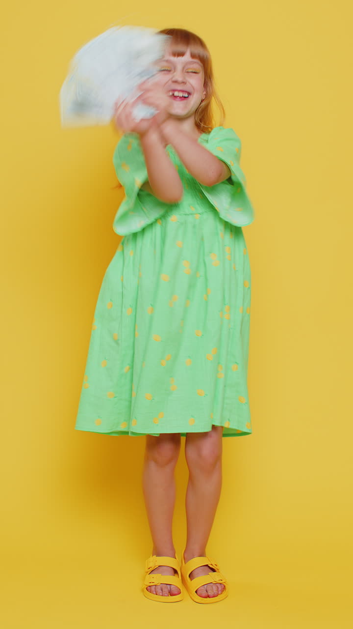 Rich pleased girl child kid waving money dollar cash bills success lottery winner income wealth