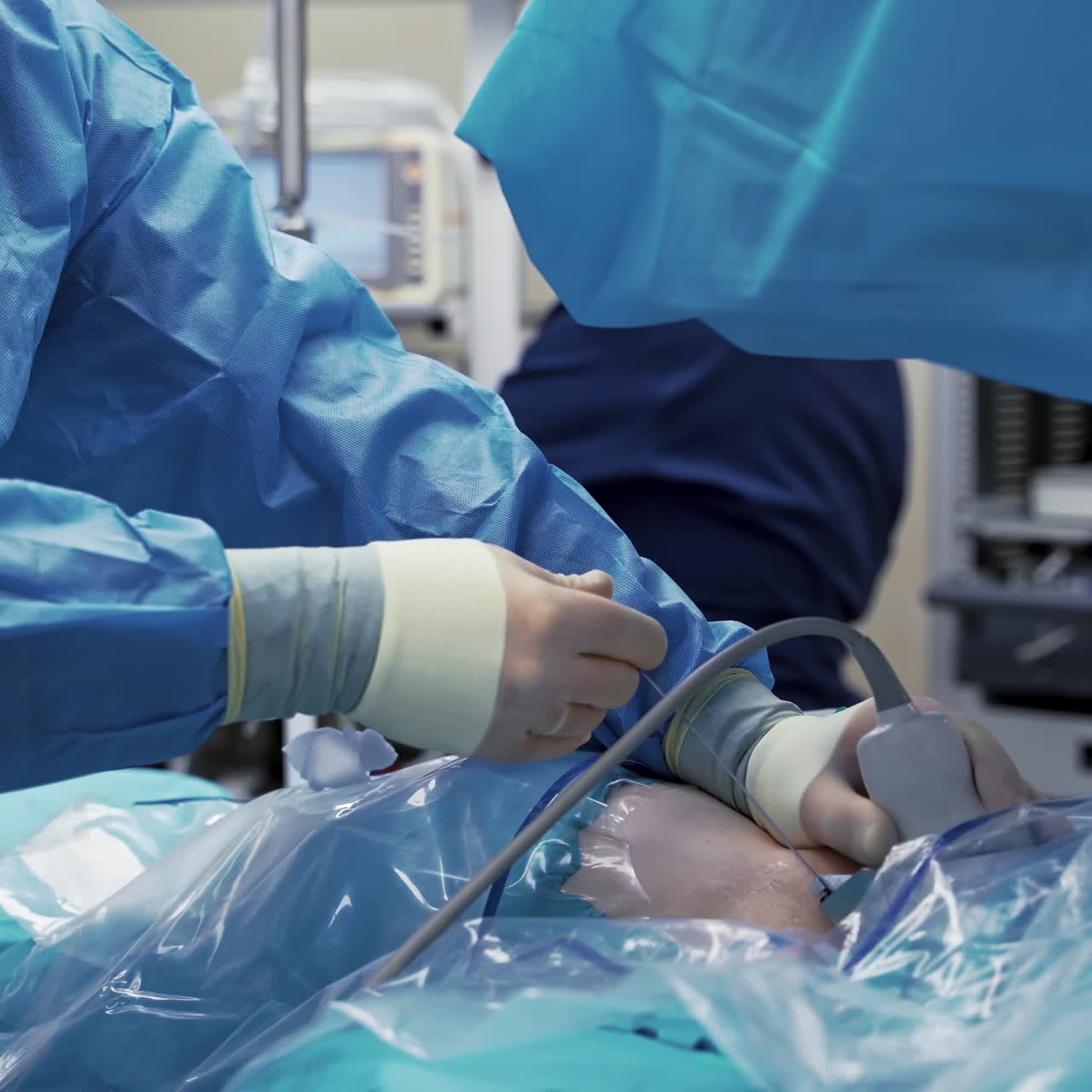 Medical specialists in modern operating room. Doctors perform a surgery and looking on the process on the monitor. Video