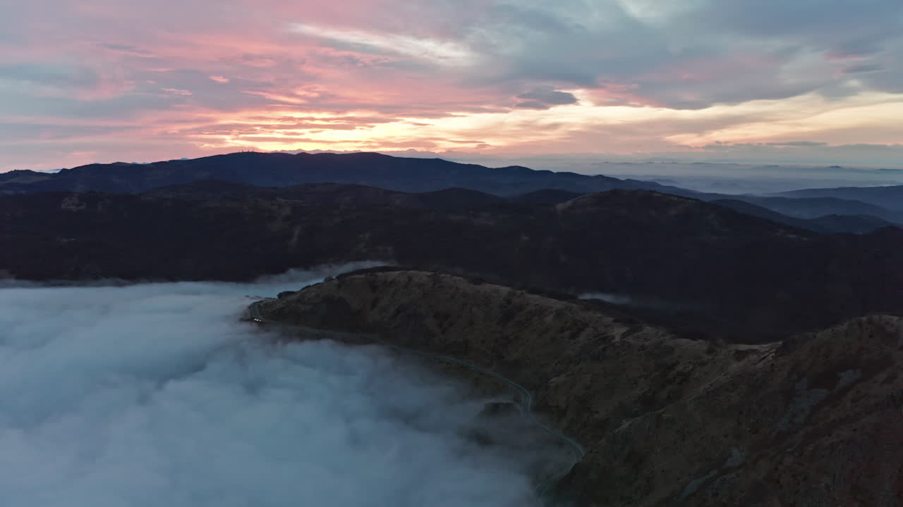 cordillera nebulosa al atardecer con nubes envolviendo valles, vista aérea