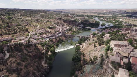 dynamic sinking aerial of puente de san martin bridge in toledo, spain