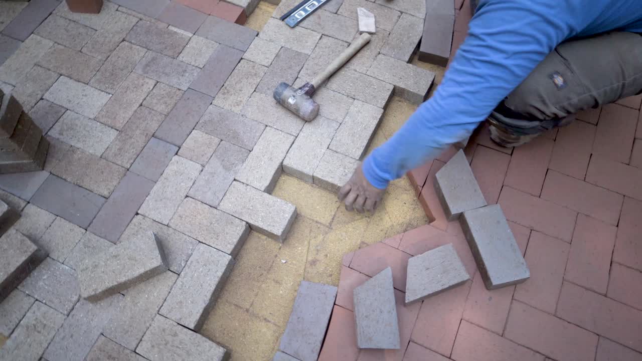 Bricklayer Laying Herringbone Pattern Patio Pavers