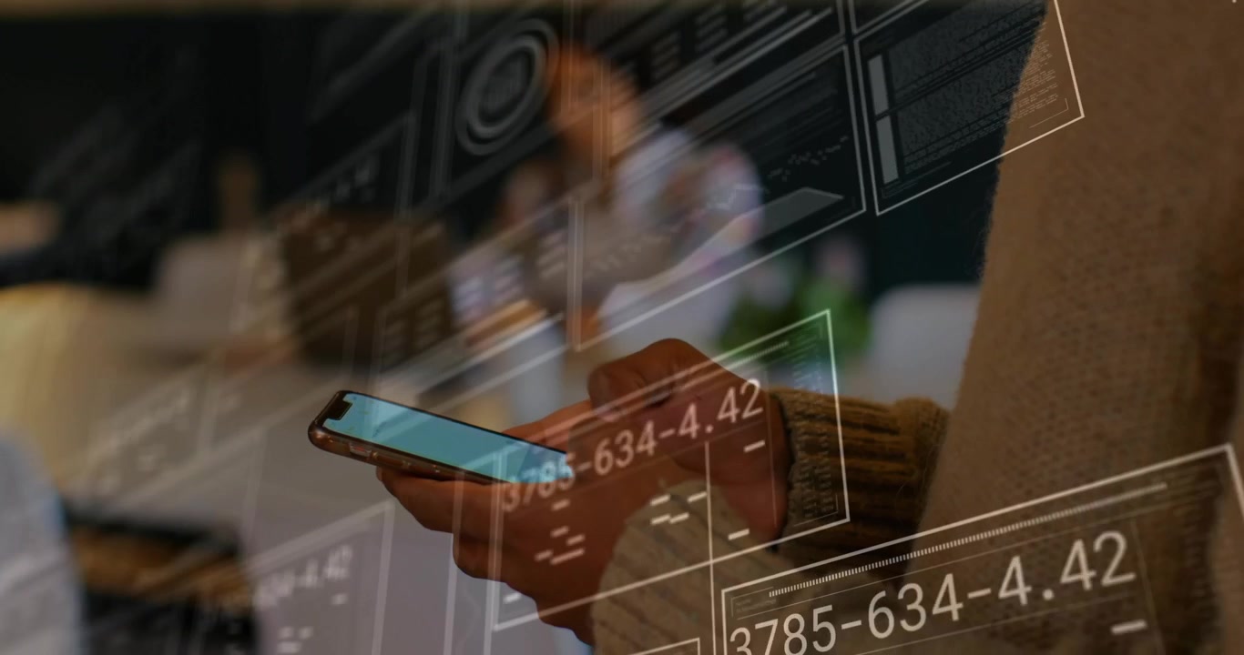 Hands lifting smartphone in tech workspace, starting AR panels and line graphs for analysing data