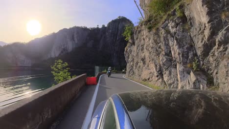 conduciendo por la carretera costera del lago iseo en un tesla capturando el panorama trasero