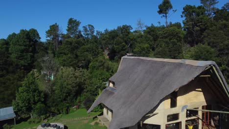 tiro de drone de una granja ecológica en hogsback, sudáfrica - drone está volando sobre la casa de huéspedes de madera