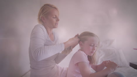 animation of glowing spots over happy caucasian mother making ponytail for her daughter