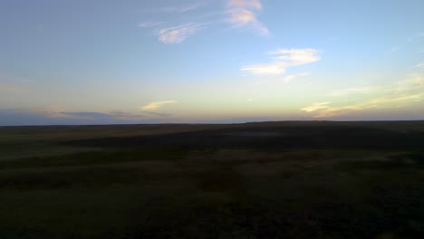 backward flight during sunset with whisky colored clouds and shadowy earth below