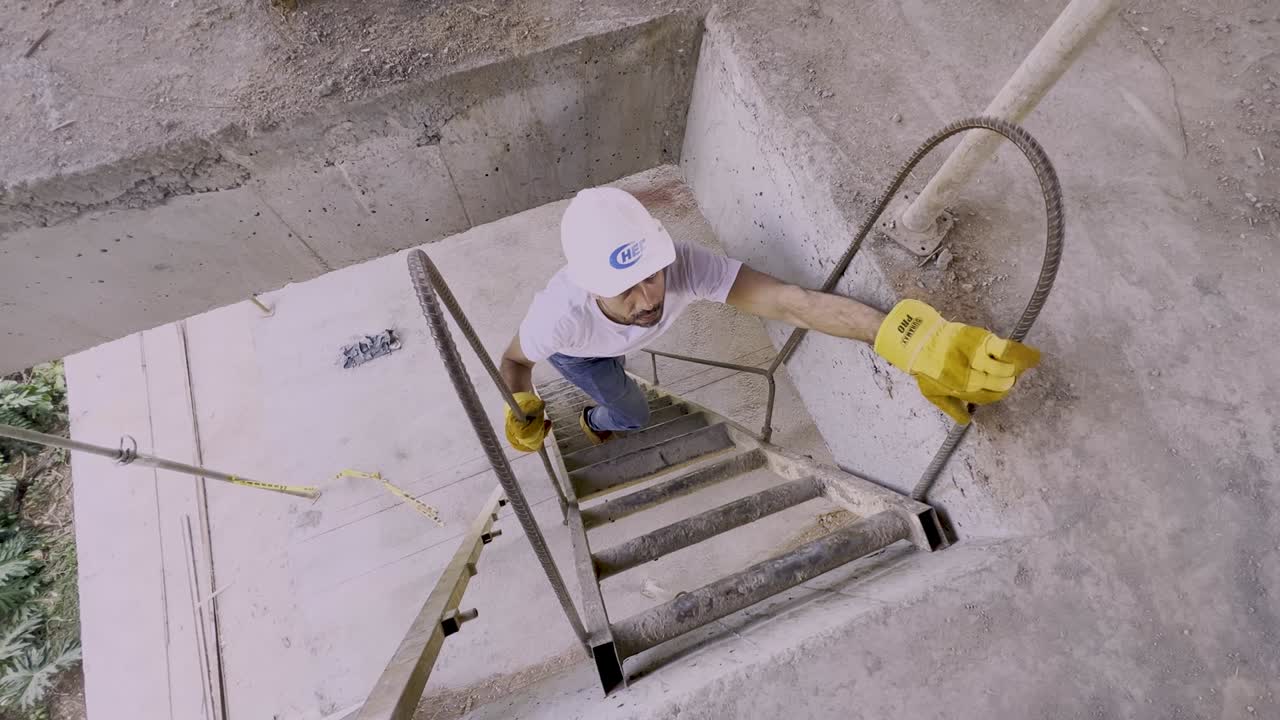 trabajador con casco subiendo escaleras dentro del sitio de construcción