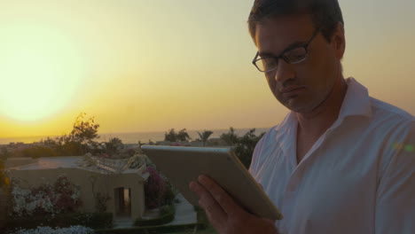 man with tablet pc at sunset