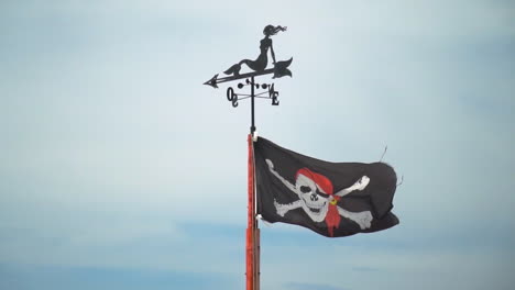 black pirate flag with skull and bones waving in slow motion