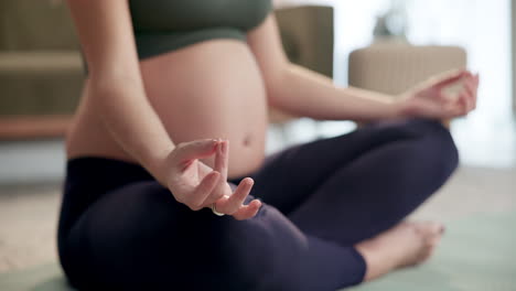 mujer embarazada practicando yoga y meditación en casa