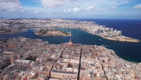 Paisaje-Aéreo-Sobre-El-Casco-Antiguo-De-La-Valeta,-Con-Sliema-Y-La-Isla-Manoel-Al-Fondo