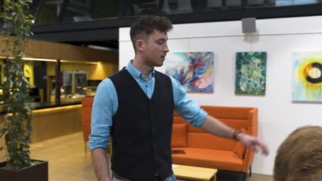 young businessman in a waistcoat scared by a llama in an office