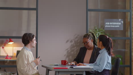 young male candidate having job interview with female recruiters