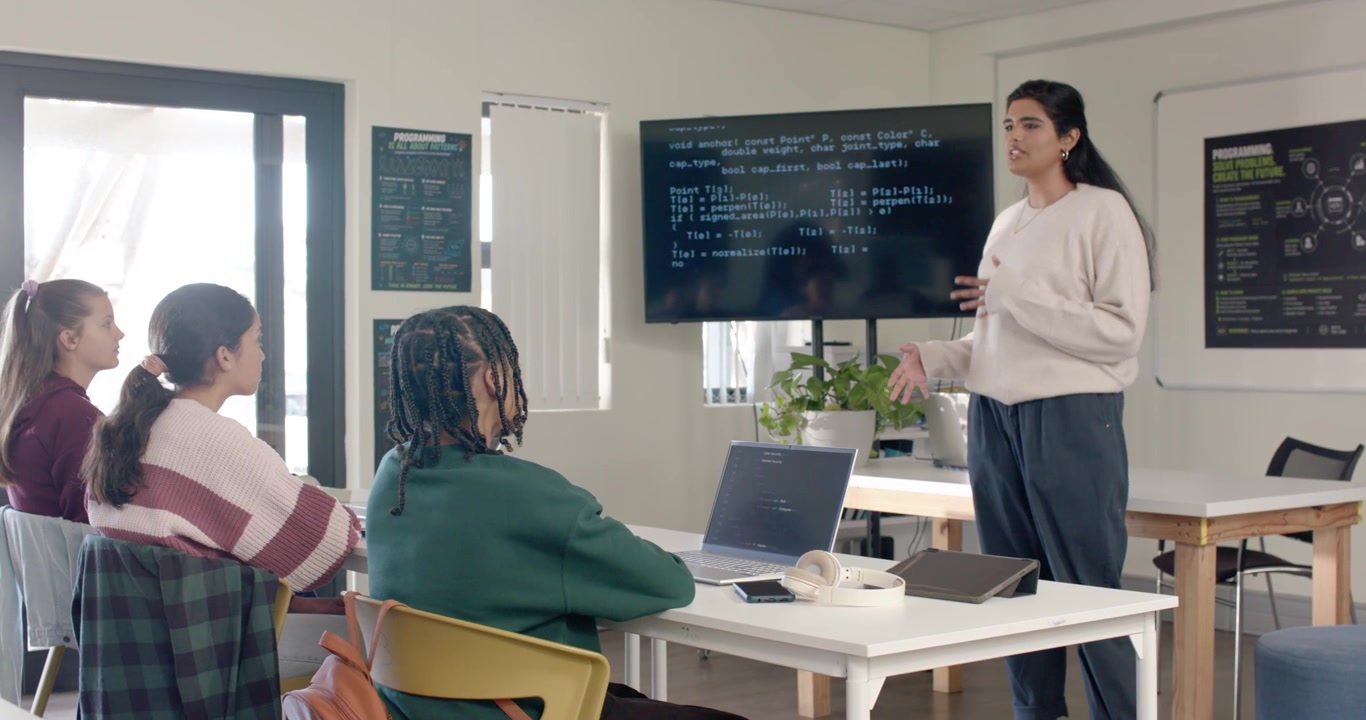 Indian woman teacher reacting to code on screen, speaking and gesturing, teaching class, copy space